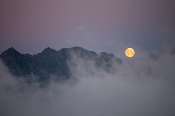 Moon over the clouds in Tatry, Poland