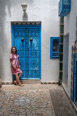 beautiful girl and blue door in Sidi Bou Said, Tunisia, Africa