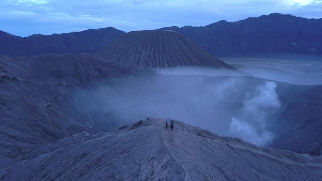 AERIAL: A hikers walks at the edge of Bromo volcano in Java island, Indonesia