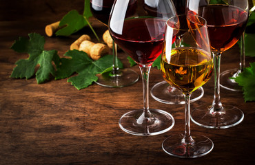 Wine set. Red, white and rose wine in assortment in wineglasses. Wine tasting, vintage wooden background, selective focus, copy space