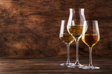 White wine set. Wine tasting, the most popular varieties of white wines in wine glasses on vintage wooden table in rustic style, selective focus