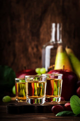 Rakija, raki or rakia - Balkan hard alcoholic drink or brandy from fermented fruits, old wooden table, still life, copy space - obrazy, fototapety, plakaty