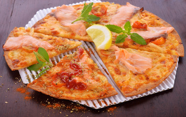 Pizza smoked salmon and lemon on wooden background