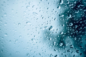 close up Rain drop on glass pane with blue background, Water drops on glass,Use for wallpaper