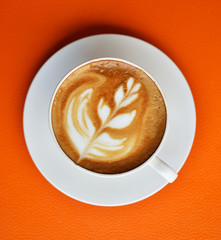 A Cup of hot latte art coffee on table