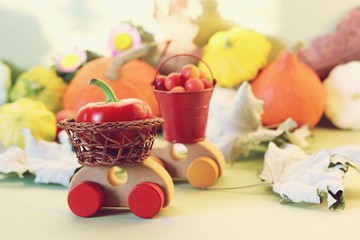  Decorative composition of toy cars, pumpkins, autumn vegetables, fruits, flowers and leaves, the concept of harvesting, natural abundance, Thanksgiving, Halloween