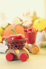  Decorative composition of toy cars, pumpkins, autumn vegetables, fruits, flowers and leaves, the concept of harvesting, natural abundance, Thanksgiving, Halloween