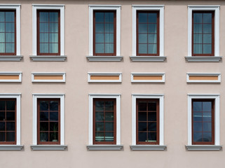 Fototapeta na wymiar Regular facade of a restored building. Wall and rows of windows