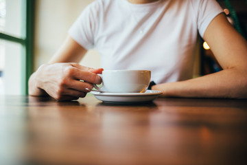 Cup of coffee in female's hand