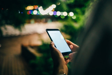 Close-up of young woman holding smart phone