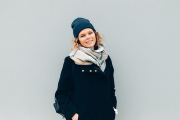 Happy female outdoors near wall in winter