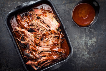 Traditional barbecue wagyu torn to bits pulled beef in hot chili sauce in a roasting dish as top...