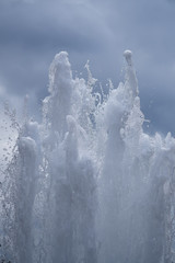 Stormy streams and jets of water of a fountain against a dark sky