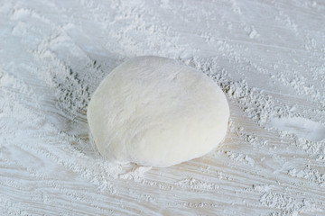 dough with flour on a white background; Dough ready for cooking