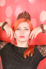 Woman enjoying tasty aroma of coffee and wear crown with coffee beans on red christmas background