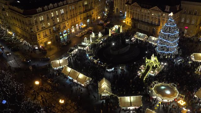 Crowded Christmas market with Christmas tree and stores at Old Town Square in Prague, Czech Republic at night - top view