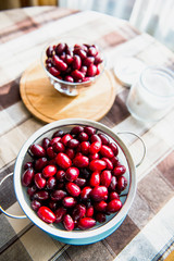 Fresh cornel berries on the kitchen table