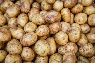 A full frame photograph of an abundance of potatoes for sale on a market stall