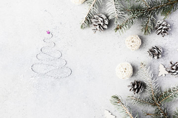Christmas background with a gifts, fir tree branches, cones and snow on gray concrete table. Christmas composition. Flat lay. Top view