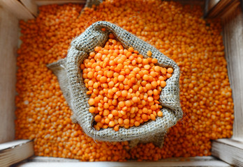 Red lentils in sack, closeup.