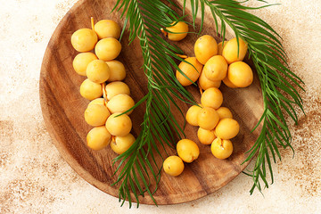 Fresh raw yellow dates with palm leaf