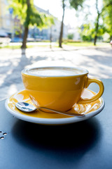 A cup of coffee on the table. A fresh morning in a street cafe.  