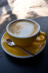A cup of coffee on the table. A fresh morning in a street cafe.  