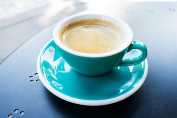 A cup of coffee on the table. A fresh morning in a street cafe.  