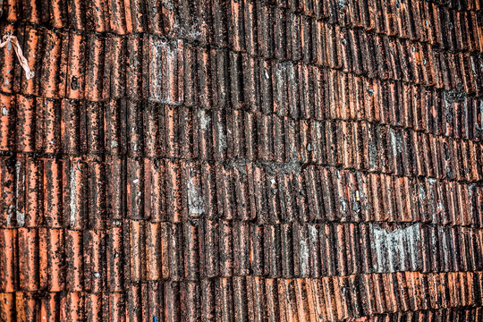 Top shot of the old-styled rectangular-shaped rooftop tiles fixed on a roof of the house.