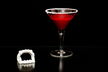 Bloody Halloween vampire drink on black background with space for copy text.