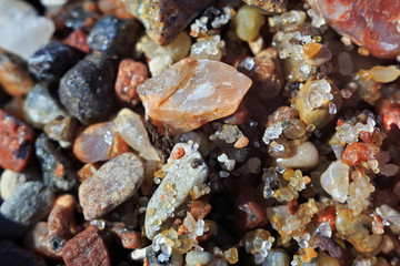 Texture of the small wet coastal sea pebbles and sand.