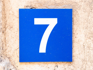 Number 7, seven, street number sign on the wall