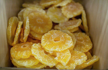Candied yellow pineapple slices in a box. Dry fruit dessert 