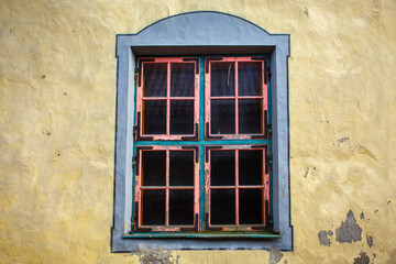 Obraz premium Window with a pink frame in the wall of an old traditional historical estonian house.