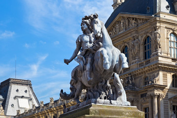Fototapeta na wymiar Sculpture of the Louis XIV king near the Louvre buildings in Paris, France. Is the world's largest art museum and is housed in the Louvre Palace, originally built in the 12-13 century.