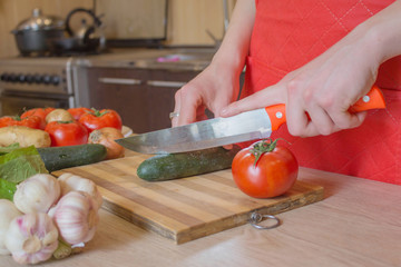 woman hands cutting vegetables on kitchen blackboard. Healthy food. Woman preparing vegetables, cooking healthy meal in the kitchen