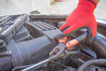 Auto mechanic working in garage during the maintenance of engine. repairing car
