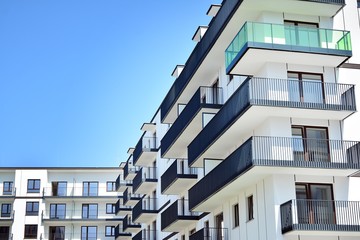 Obraz premium Modern apartment buildings on a sunny day with a blue sky. Facade of a modern apartment building