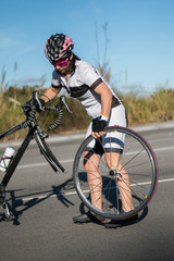 Ciclista femenina reparando bicileta