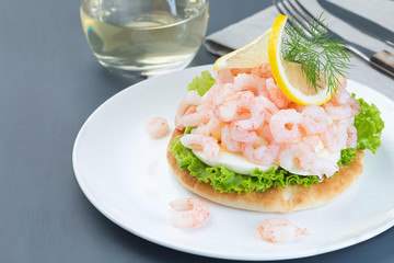 Traditional savory swedish sandwich with soft white bread vetekaka, lettuce, eggs, mayonnaise, shrimps, dill and lemon, horizontal, copy space