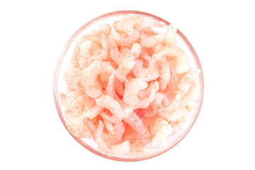 Frozen raw peeled shrimps in a glass bowl, isolated on a white, top view