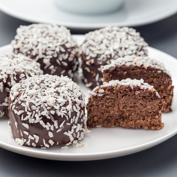 Swedish Sweets Chocolate Balls Or Chokladbollar, Made From Oats, Cocoa, Butter And Coconut, On A White Plate, Served With Coffee, Square Format, Closeup