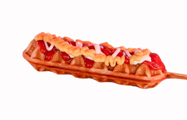 Selective focus of hot dog waffle on a stick in isolated white background. Hot dog waffle is ready to eat.