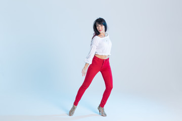 Latin dance, contemporary dance, bachata solo and cha-cha-cha concept - portrait of a young woman salsa dancer in a dance pose on blue background with copy space