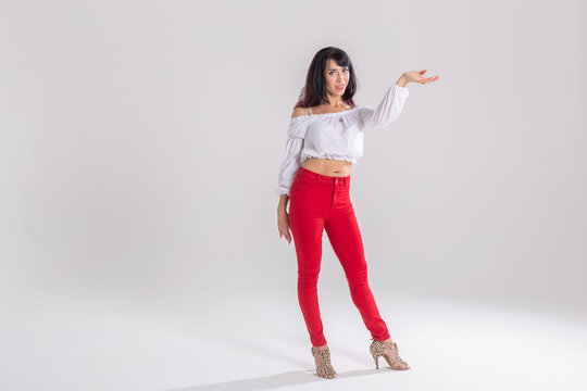 Latin dance, contemporary dance, bachata solo and cha-cha-cha concept - portrait of a young woman salsa dancer in a dance pose on white background with copy space