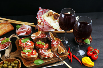 Fototapeta na wymiar Italian antipasti wine snacks set. Cheese variety, Mediterranean olives, Prosciutto di Parma, tomatoes, artichokes