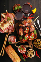 Obraz na płótnie Canvas Italian antipasti wine snacks set. Cheese variety, Mediterranean olives, Prosciutto di Parma, tomatoes, artichokes