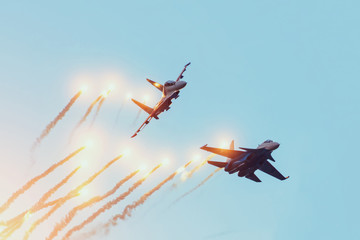 Two combat fighters jet perform an air battle with the firing of warheads with explosions.