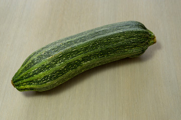 Zucchini is a bush variety of pumpkin ordinary with oblong fruits, without lashes. Fruits can be green, yellow, black or white. Vegetable on a colored background.