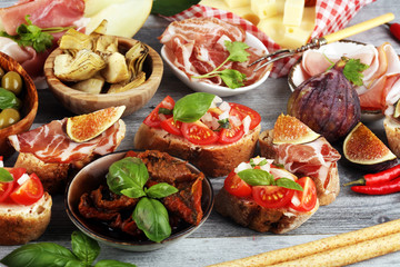 Italian antipasti wine snacks set. Cheese variety, Mediterranean olives, Prosciutto di Parma, tomatoes, artichokes